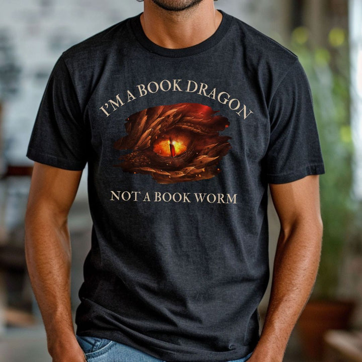 A man wearing a short sleeve heather black t-shirt. Design on the shirt reads "I'm a book dragon not a book worm." Between the text is the red dragon eye from the cover of Firesight.