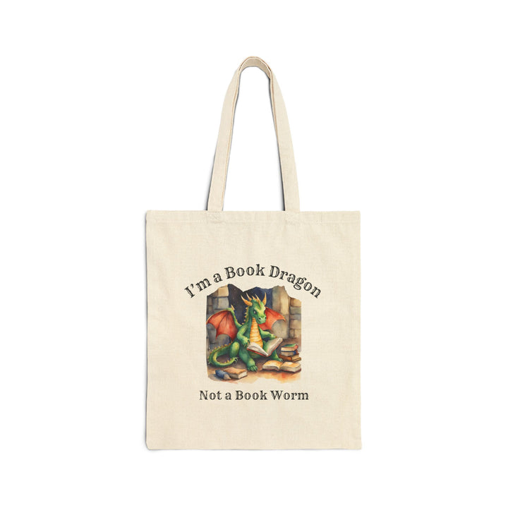 A canvas tote bag. Design on the bag reads "I'm a book dragon not a book worm." Between the text is a watercolor design of a dragon reading next to a stack of books.