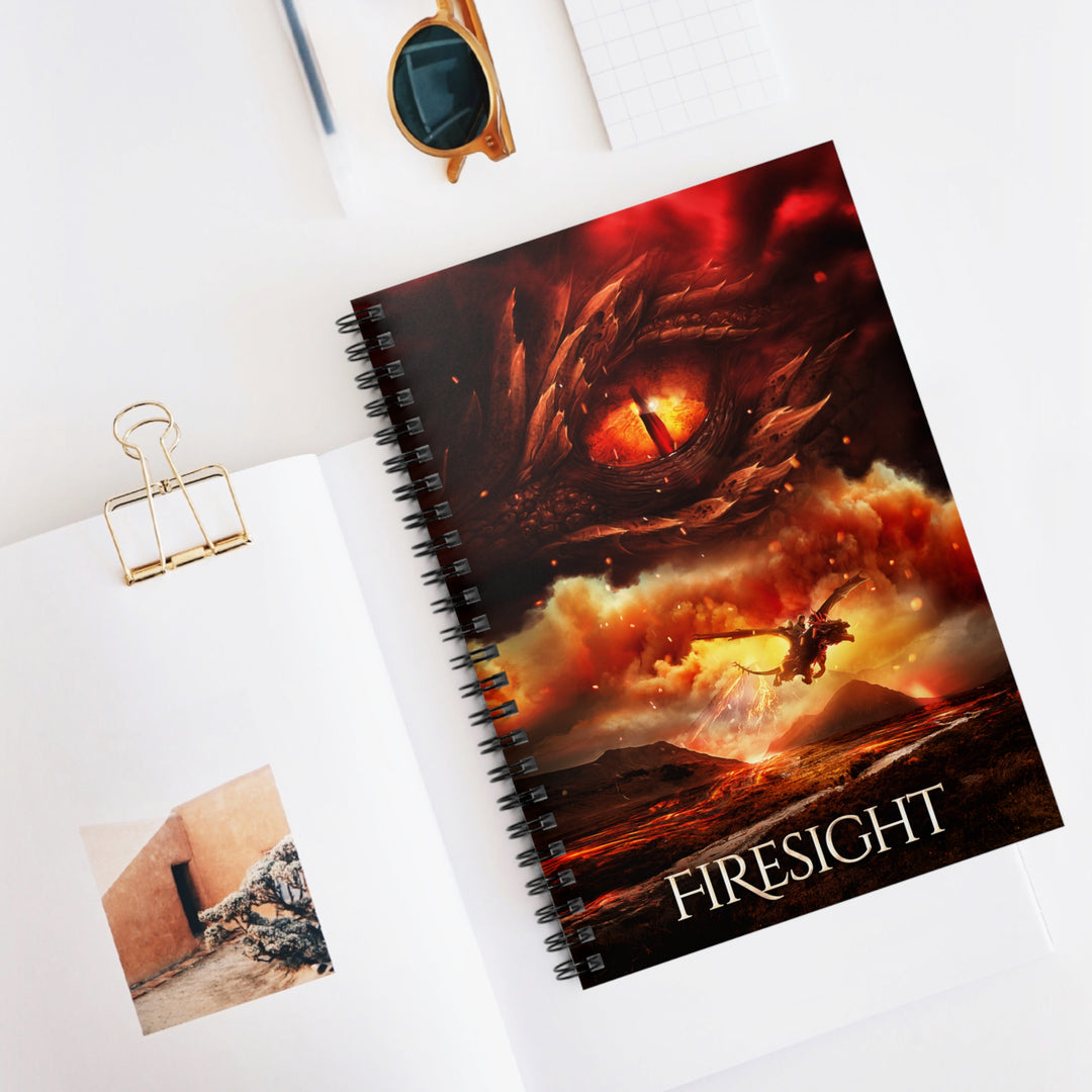 A notebook with the cover featuring the artwork from the cover of Firesight. Artwork features a red dragon eye at the top. Below the eye, the two main characters ride on a dragon over a volcano erupting. The title is at the bottom of the notebook cover.