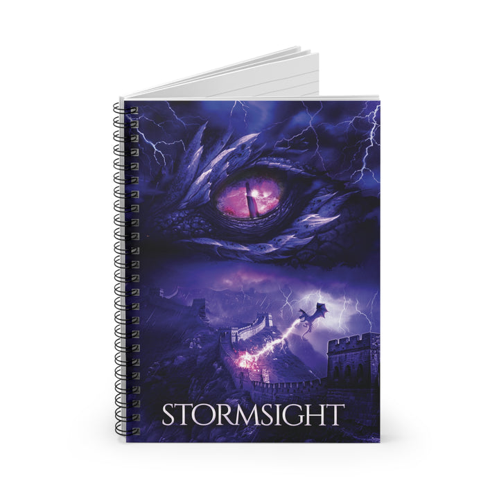 A notebook with the cover featuring the artwork from the cover of Stormsight. Artwork features a purple dragon eye at the top. Below the eye, a dragon breathes lightning onto a wall. The title is at the bottom of the notebook cover.