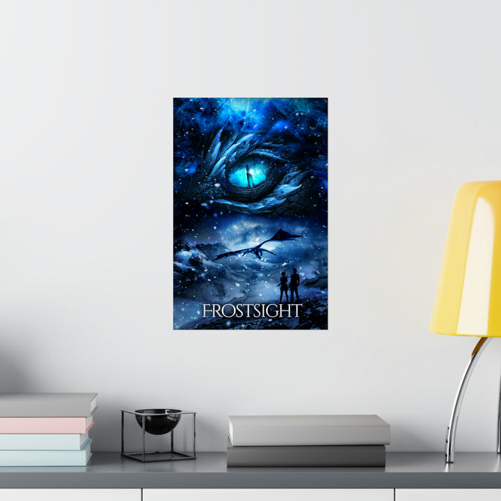 A poster hanging on a wall featuring the artwork from the cover of Frostsight. Artwork features a blue dragon eye at the top. Below the eye, the two main characters watch a dragon in the distance in a snowy mountain landscape. The title is at the bottom of the poster.