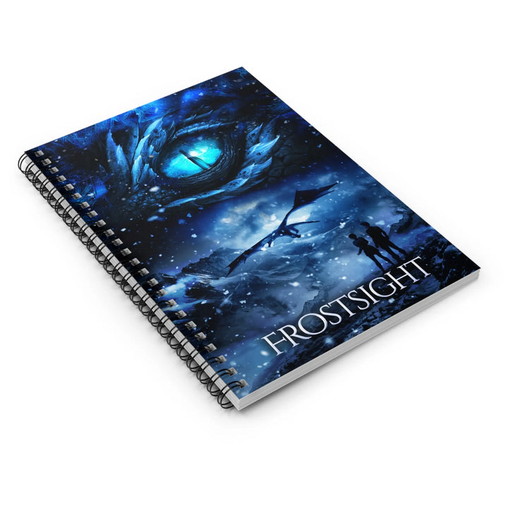 A notebook with a cover featuring the artwork from the cover of Frostsight. Artwork features a blue dragon eye at the top. Below the eye, the two main characters watch a dragon in the distance in a snowy mountain landscape. The title is at the bottom of the notebook cover.