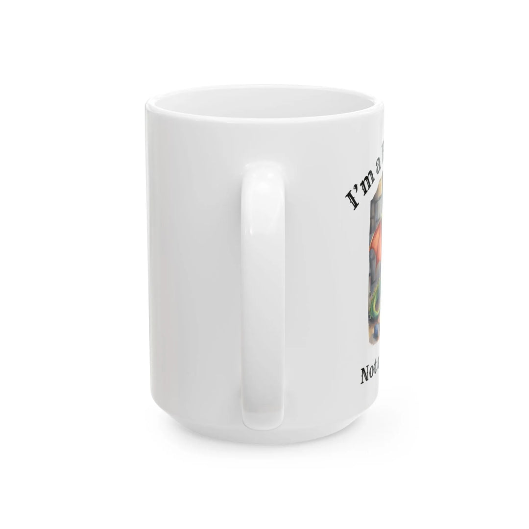 A white mug. Design on the mug reads "I'm a book dragon not a book worm." Between the text is a watercolor design of a dragon reading next to a stack of books.