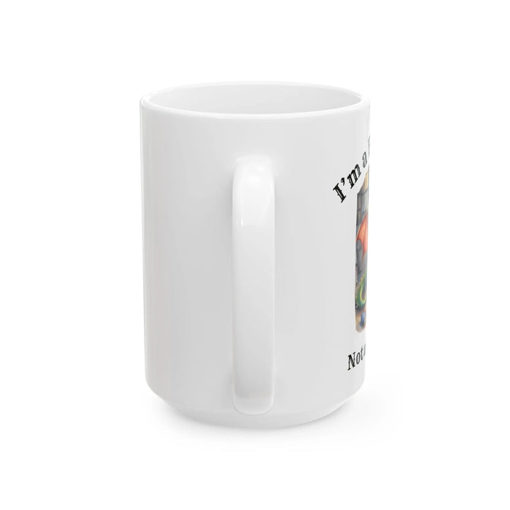 A white mug. Design on the mug reads "I'm a book dragon not a book worm." Between the text is a watercolor design of a dragon reading next to a stack of books.