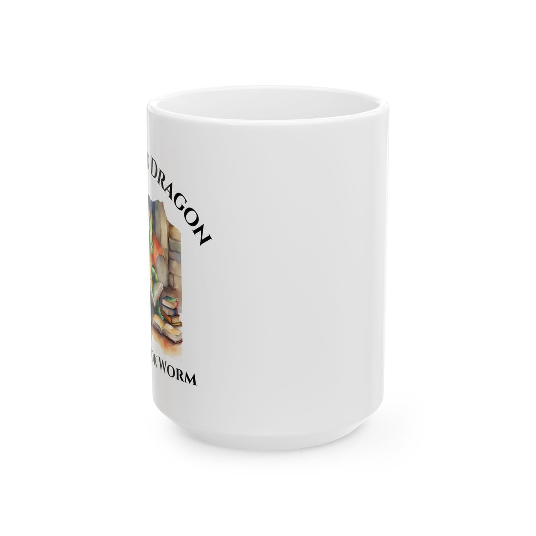 Side view of a white mug. Design on the mug reads "I'm a book dragon not a book worm." Between the text is a watercolor design of a dragon reading next to a stack of books.