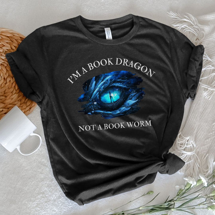 A short sleeve heather black t-shirt. Design on the shirt reads "I'm a book dragon not a book worm." Between the text is the blue dragon eye from the cover of Frostsight.