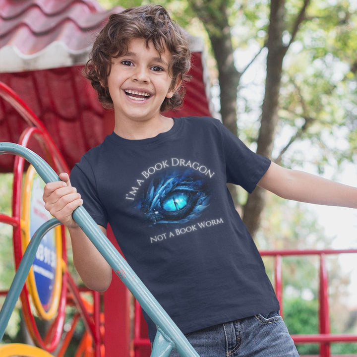 A young boy wearing a short sleeve navy t-shirt. Design on the shirt reads "I'm a book dragon not a book worm." Between the text is the blue dragon eye from the cover of Frostsight.