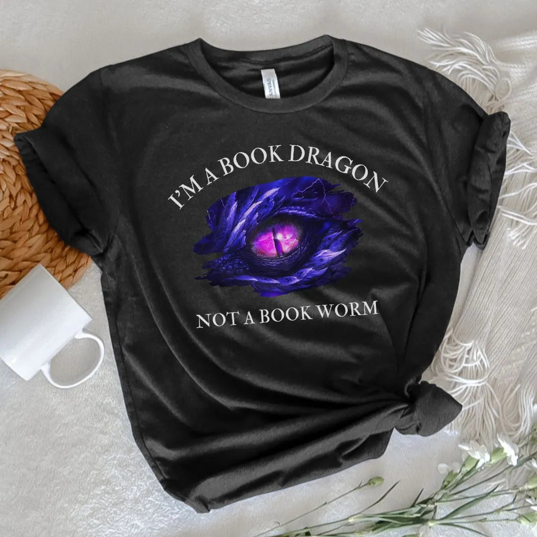 A short sleeve heather black t-shirt. Design on the shirt reads "I'm a book dragon not a book worm." Between the text is the purple dragon eye from the cover of Stormsight.