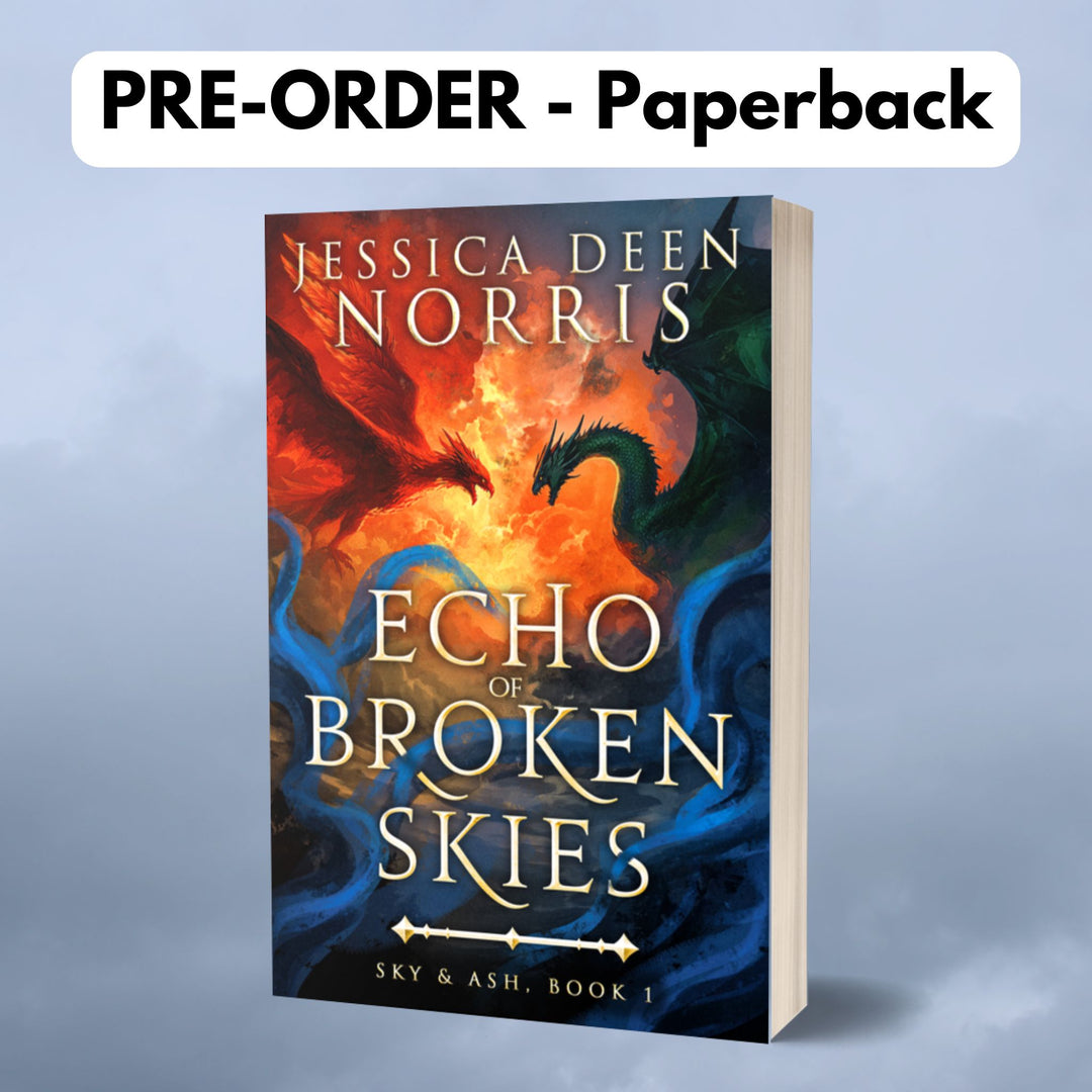 Pre-Order - Paperback - Echo of Broken Skies by Jessica Deen Norris - Cover features the author's name at the top in large serif font. The central artwork depicts a dramatic sky divided by swirling clouds of fire. On the left, a red phoenix with outstretched wings flies toward a dark green dragon on the right, both poised as if mid-battle. Blue, smoky tendrils swirl around the bottom half of the image. The title is centered in bold, metallic gold, with "Sky & Ash, Book 1" below a decorative gold divider.