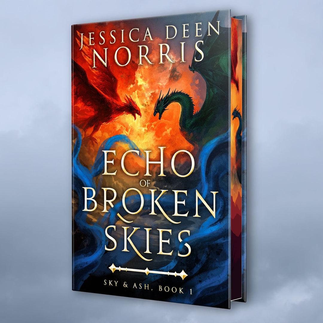 Hardcover - Echo of Broken Skies by Jessica Deen Norris - Cover features the author's name at the top. The artwork depicts a sky divided by swirling clouds of fire. On the left, a red phoenix with outstretched wings flies toward a dark green dragon on the right, both poised as if mid-battle. Blue, smoky tendrils swirl around the bottom of the image. The title is centered in metallic gold, with Sky & Ash, Book 1 below a decorative gold divider. Sprayed edges feature the dragon and phoenix.