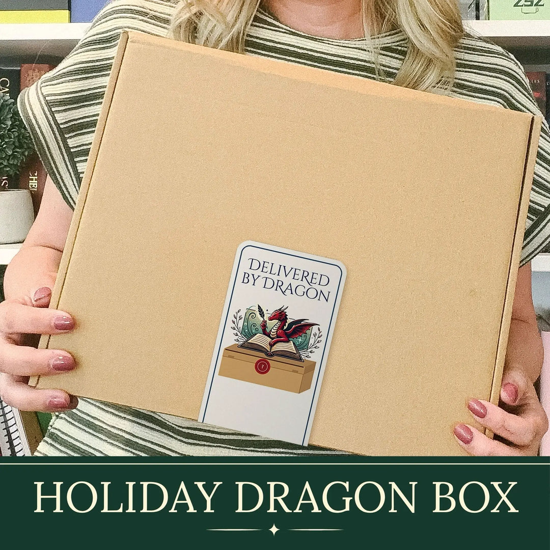 A person holds a large brown cardboard box labeled 'Delivered by Dragon' in a real indoor setting. The box has a decorative dragon illustration and the text 'HOLIDAY DRAGON BOX' appears in a dark green banner at the bottom of the image.