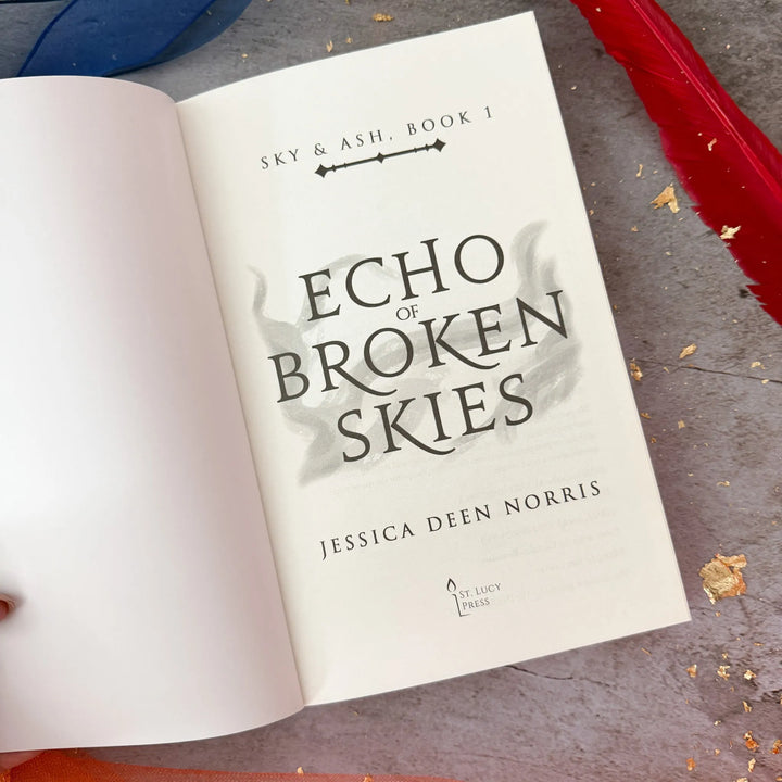 Open book titled 'Echo of Broken Skies' by Jessica Deen Norris on a textured surface.