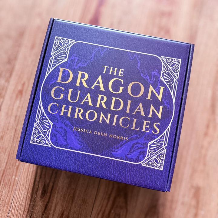 Purple book box with 'The Dragon Guardian Chronicles' on a wooden surface