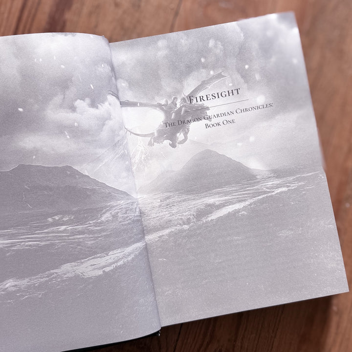 Open book with a volcanic landscape illustration and 'Firesight' title on a wooden surface