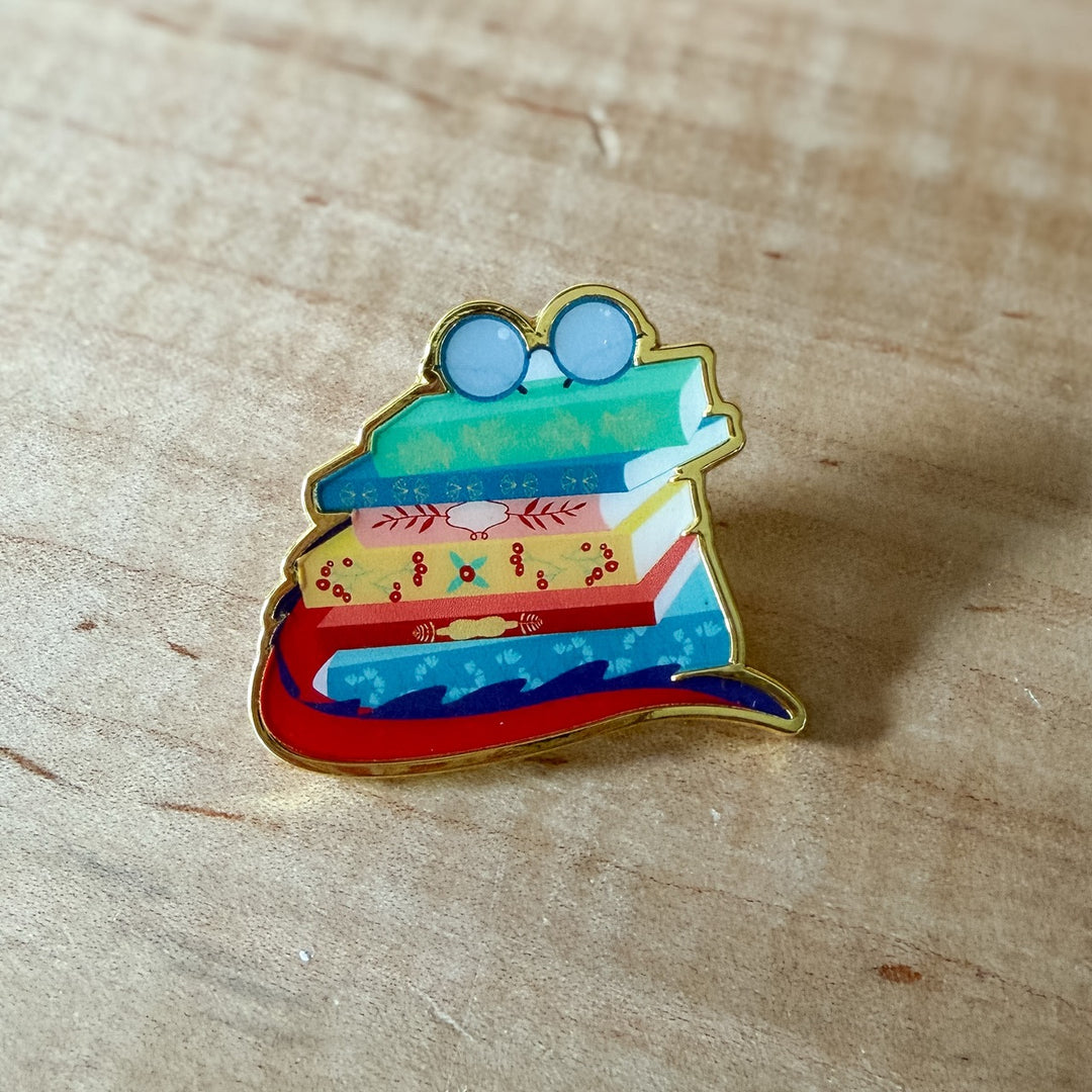 Colorful book-shaped pin on a wooden surface