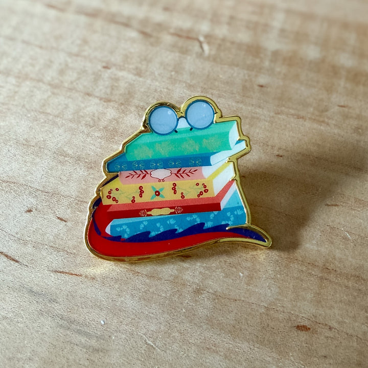 Colorful book-shaped pin on a wooden surface