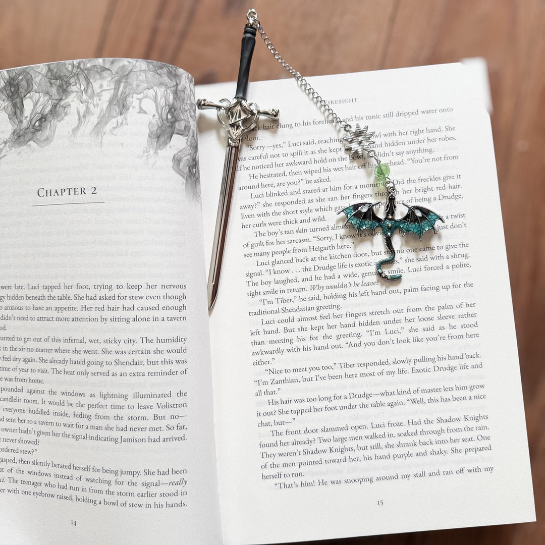 Decorative sword bookmark with dragon charm on an open book