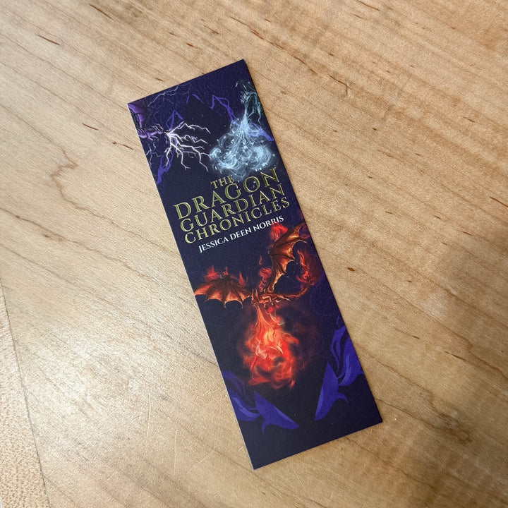 Bookmark with 'The Dragon Guardian Chronicles' design on a wooden surface