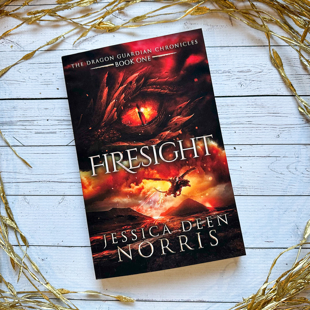 Firesight paperback cover. Cover features the title across the middle with a red dragon eye and "The Dragon Guardian Chronicles Book 1" above it. Below the title, the two main characters ride on a dragon over a volcano erupting. The author's name is at the bottom of the cover.
