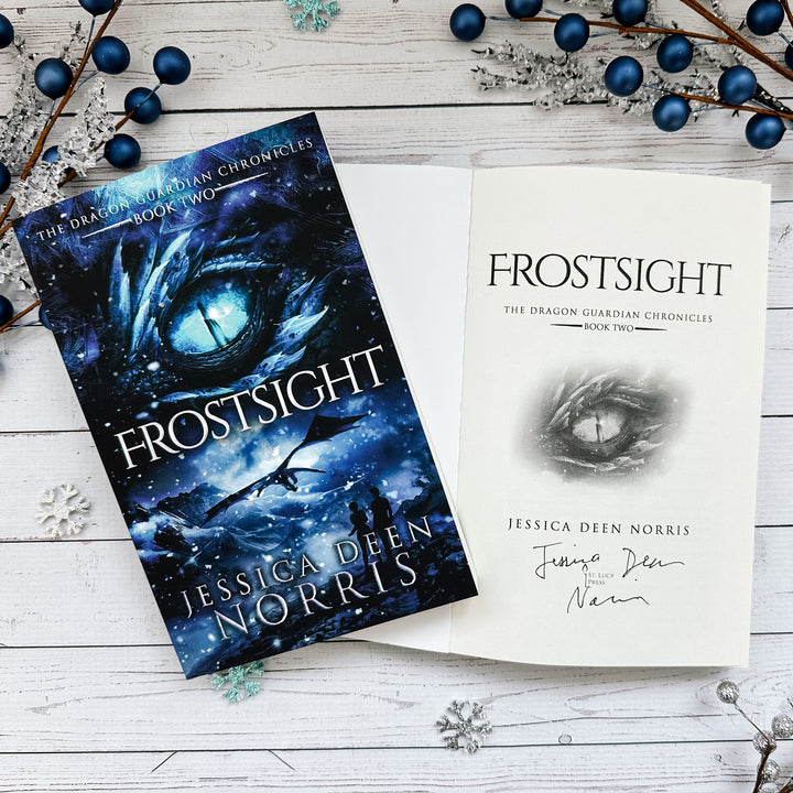 Frostsight book cover and another copy open to the title page with the author's signature
