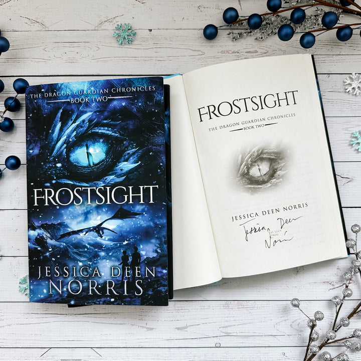 Frostsight book cover and another copy open to the title page with the author's signature