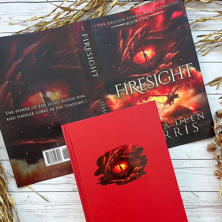 Firesight full dust jacket shone with the book underneath (which is solid red featuring a red dragon eye). Cover features the title across the middle with a red dragon eye and "The Dragon Guardian Chronicles Book 1" above it. Below the title, the two main characters ride on a dragon over a volcano erupting. The author's name is at the bottom of the cover. The back of the cover says "The power of the light blinds him, and danger lurks in the shadows..."