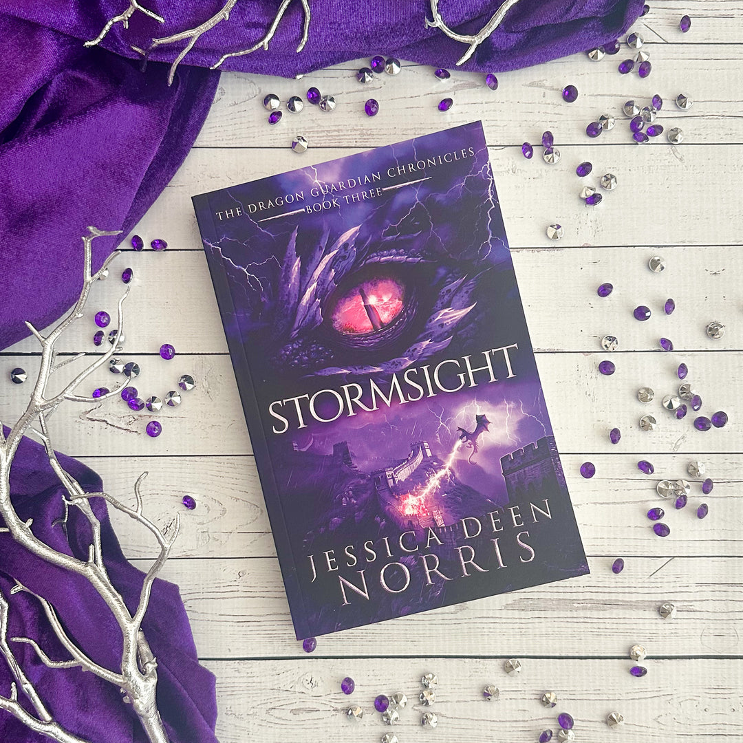 Stormsight paperback cover. Cover features the title across the middle with a purple dragon eye and "The Dragon Guardian Chronicles Book 3" above it. Below the title, a dragon breathes lightning onto a huge stone wall. The author's name is at the bottom of the cover.