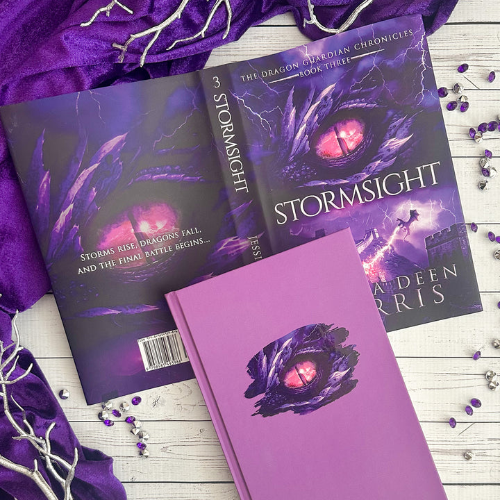 Stormsight full dust jacket shone with the book underneath (which is solid blue featuring a purple dragon eye). Cover features the title across the middle with a purple dragon eye and "The Dragon Guardian Chronicles Book 3" above it. Below the title, a dragon breathes lightning onto a huge stone wall. The author's name is at the bottom of the cover.#autograph-option_signed-by-author