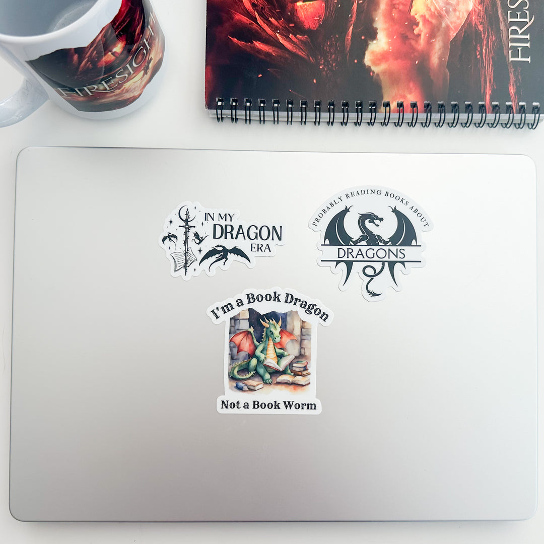 Three dragon fan stickers on a laptop